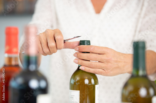woman opening wine bottle closeup