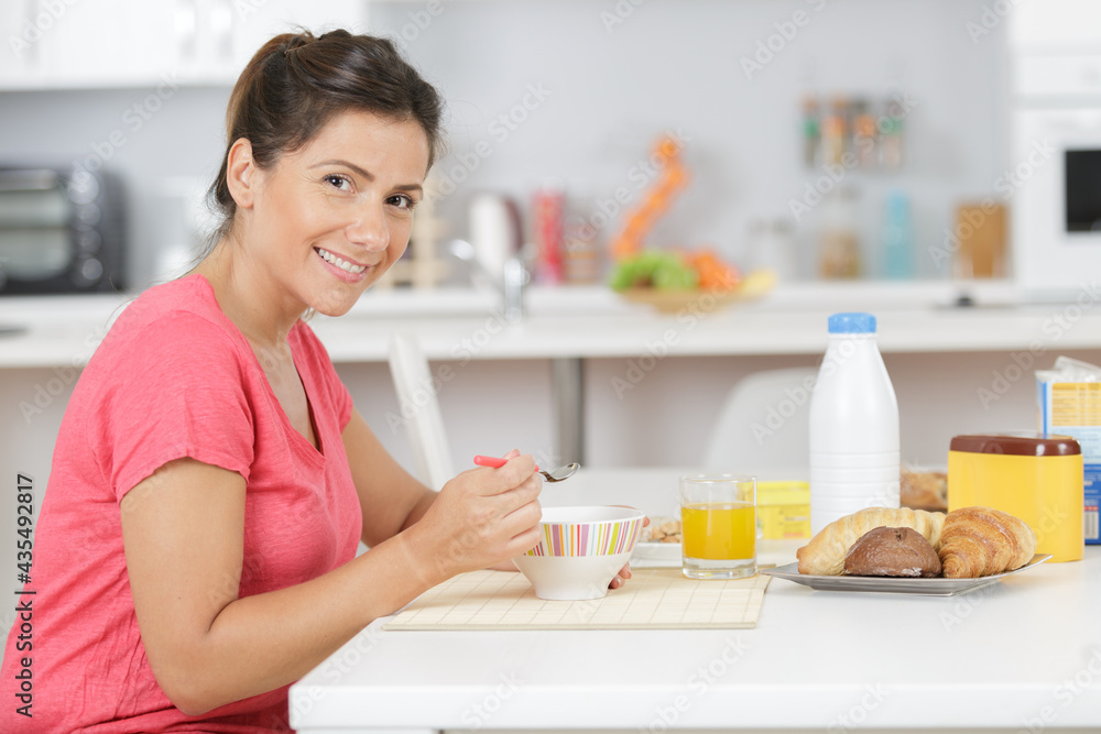 portrait of woman eating breakfast cereals at home