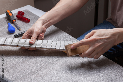 Guitar technician repairing the neck of a guitar.