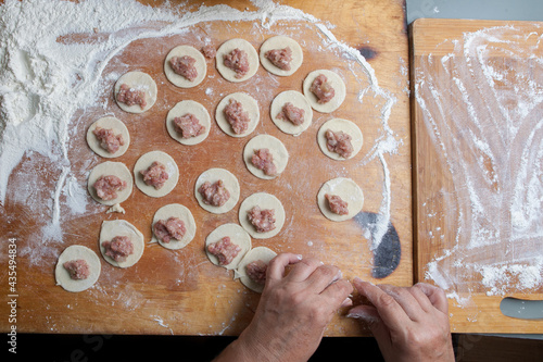 the process of handmade dumplings on a wooden board.