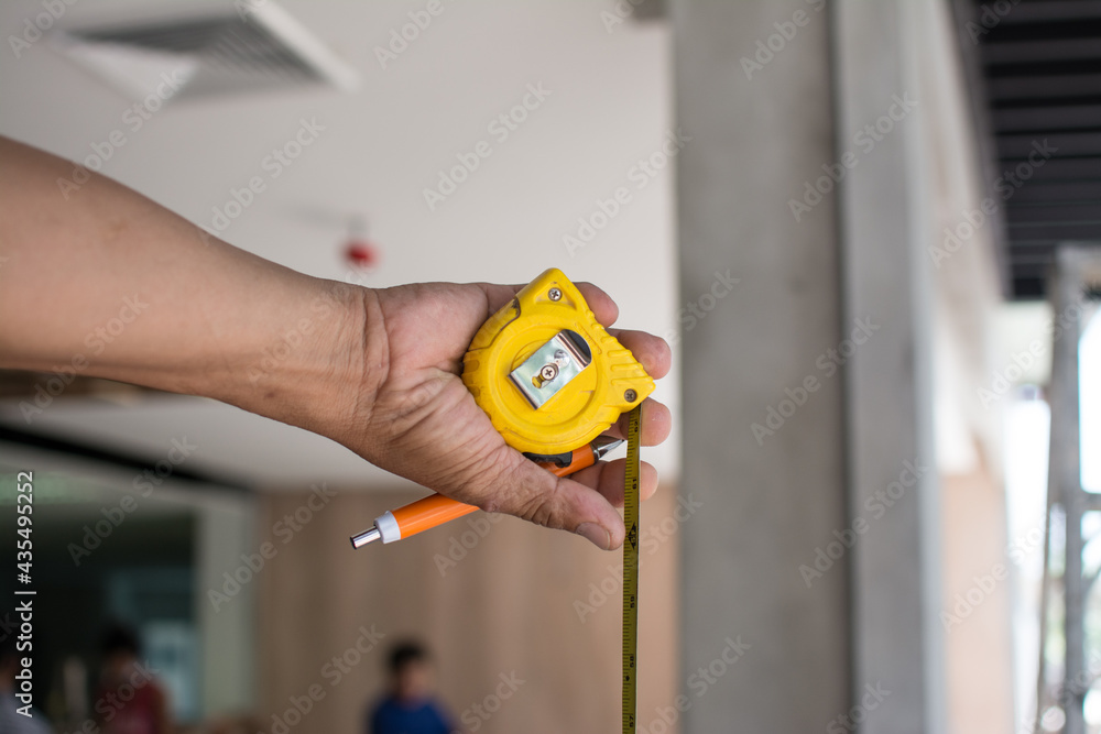 using tape measure for measuring size of wooden furniture