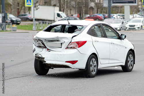 Collision of cars. The white taxi car suffered severe damage to the rear of the body. Broken bumper and trunk lid. © Андрей Михайлов
