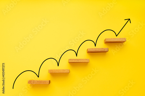 Rising arrow on staircase on yellow background. Growth, increasing business, success process concept photo