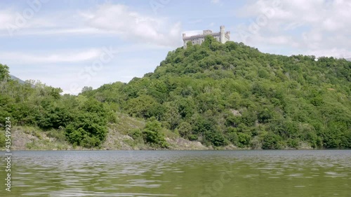 Natural lake in the foreground with castle above the hill.Pistono lake. Landscape. Ivrea. Italy. Slow motion 4K photo