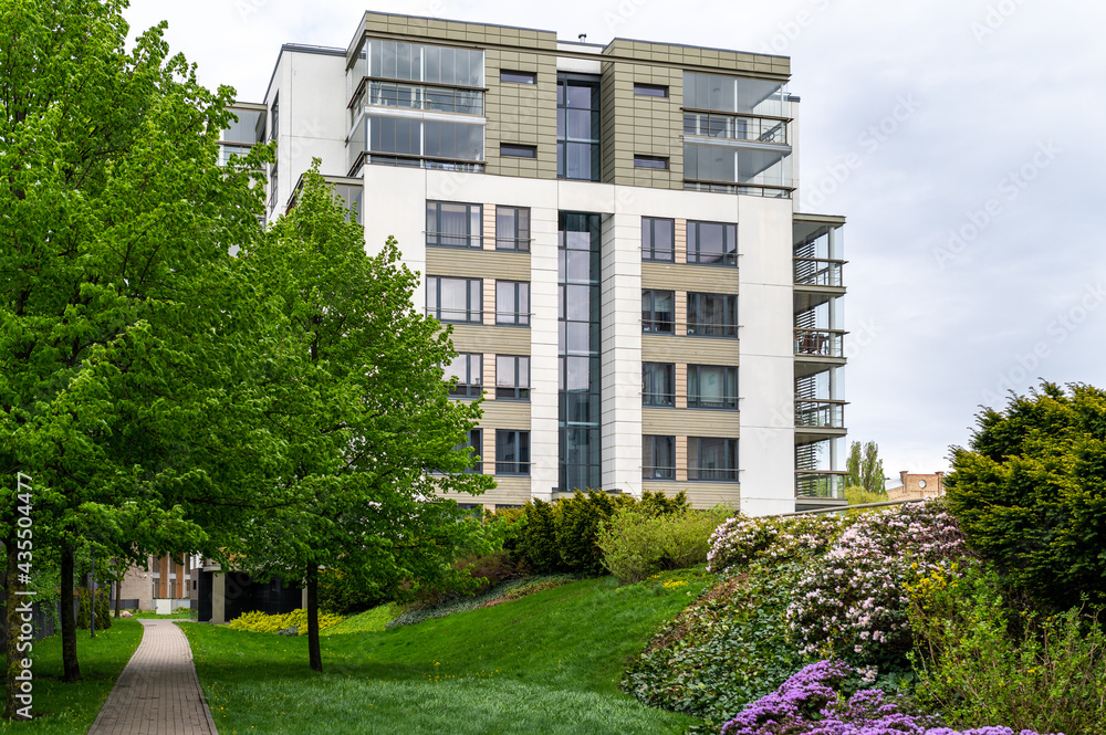 Cityscape of a residential area with modern apartment buildings, new green urban landscape in the city, green trees and flowers in garden Cityscape of a residential area with modern apartment buildings, new green urban landscape in the city, green trees and flowers in garden