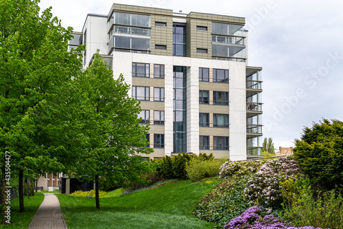 Cityscape of a residential area with modern apartment buildings, new green urban landscape in the city, green trees and flowers in garden