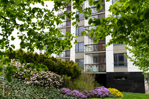 Cityscape of a residential area with modern apartment buildings, new green urban landscape in the city, green trees and flowers in garden