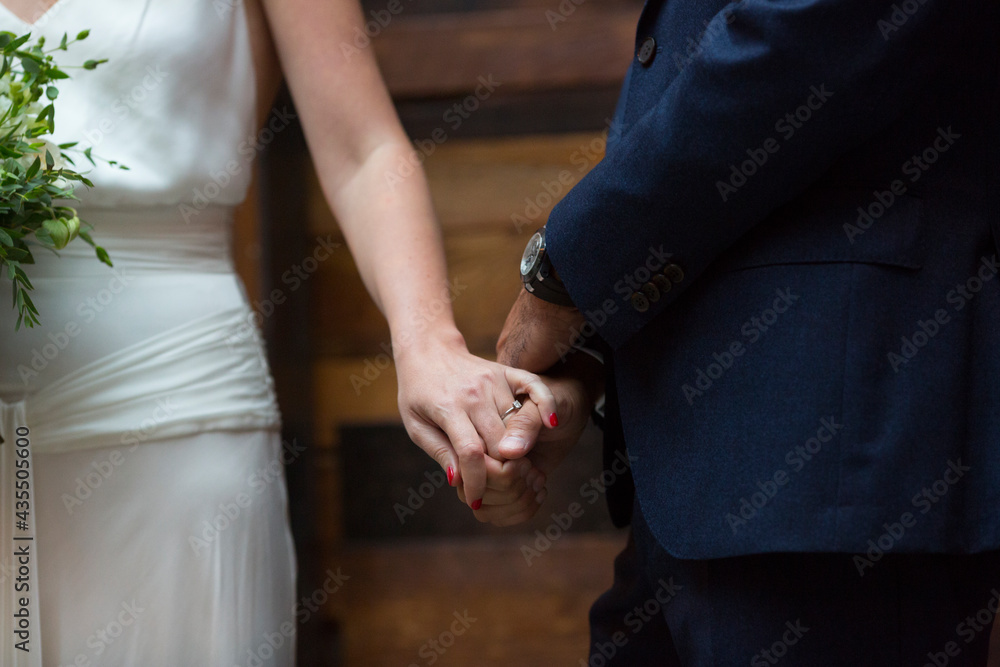 young bride and groom holding hands in their wedding