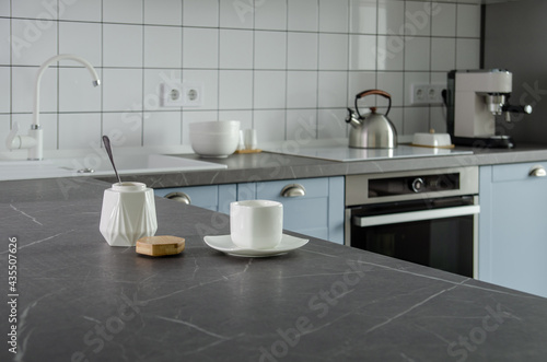 Modern stylish minimalist blue and gray kitchen with cooking utensils.