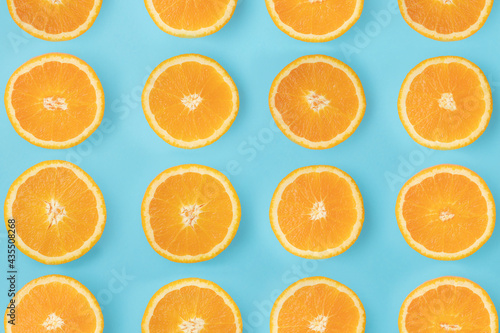 Arranged sliced ​​orange. Slices lined up on a blue background.