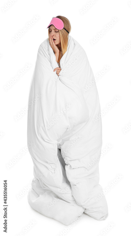 Young woman in sleeping mask wrapped with soft blanket yawning on white background Young woman in sleeping mask wrapped with soft blanket yawning on white background