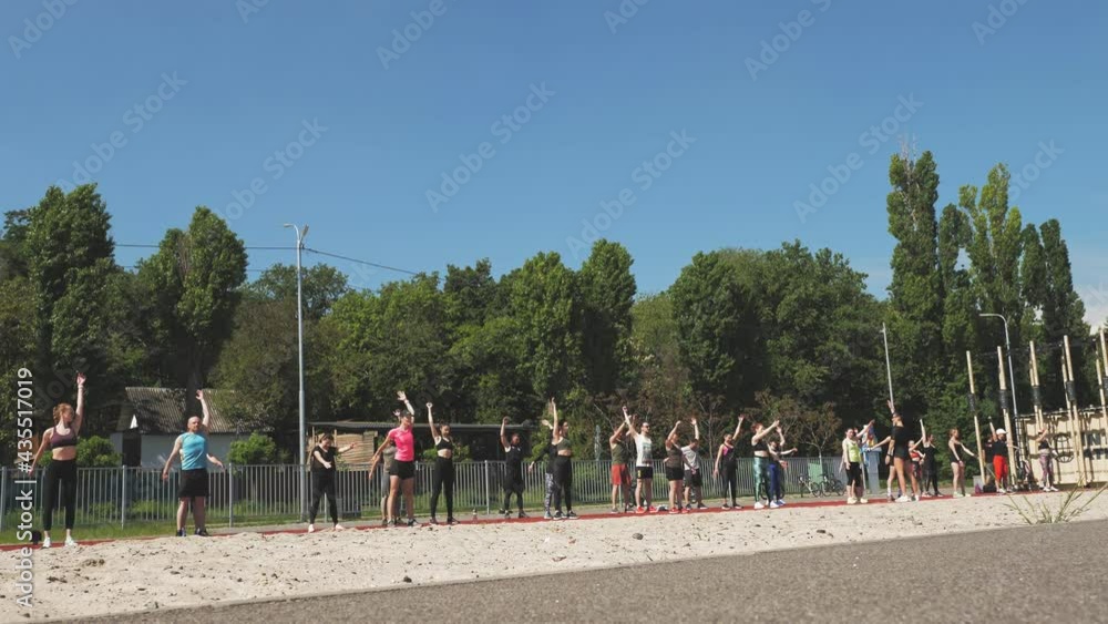 group fitness workout outdoors. fitness outdoors. Large group of people, wearing activewear, is exercising together, on sports ground, on the beach, outdoors. healthy lifestyle concept. sport outdoors group fitness workout outdoors. fitness outdoors. Large group of people, wearing activewear, is exercising together, on sports ground, on the beach, outdoors. healthy lifestyle concept. sport outdoors