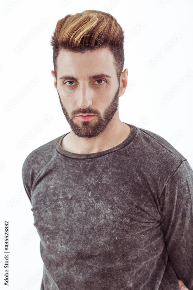 Obraz premium Chico joven de barba posa de perfil con remera 