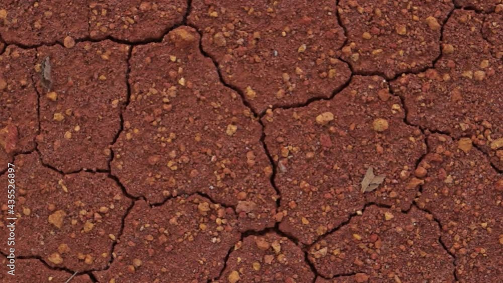 close up texture of red soil that is experiencing dryness, rotating shot.