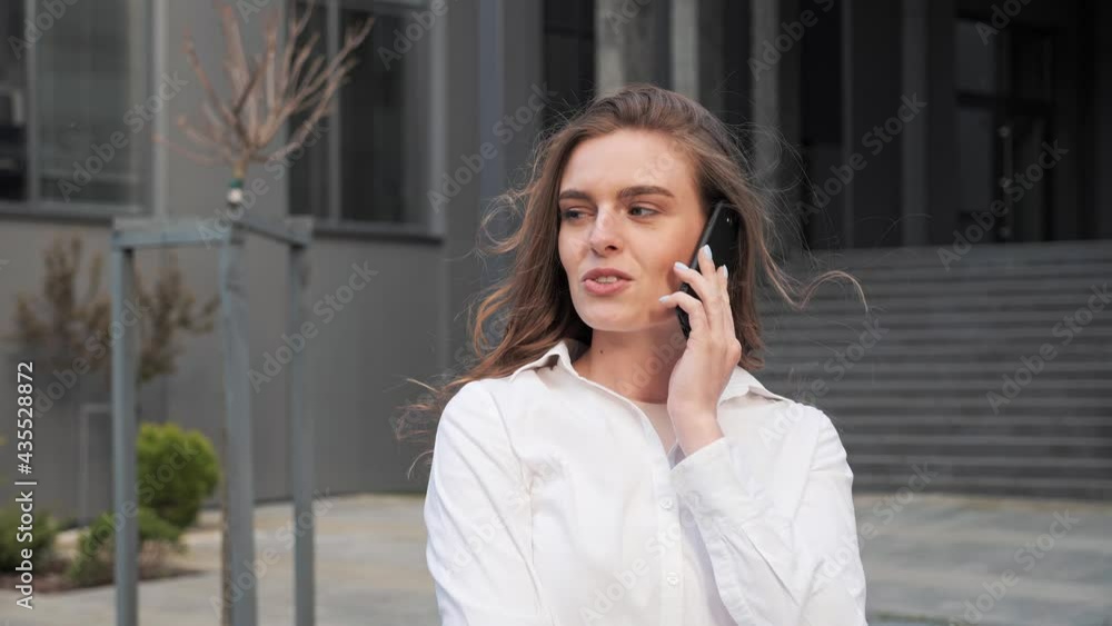 Woman standing near the business center using mobile pone for conversation. Woman standing near the business center using mobile pone for conversation.