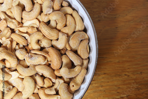 Bowl of Salted Cashews with Wooden Background