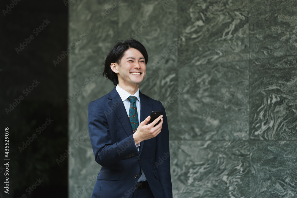 出社する若い男性・スマートフォンでIoT・ビジネスイメージ 出社する若い男性・スマートフォンでIoT・ビジネスイメージ