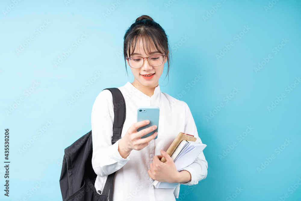 Portrait of a beautiful schoolgirl on a blue background Portrait of a beautiful schoolgirl on a blue background