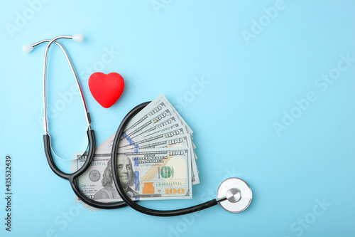 Medical stethoscope and money on a colored background top view close-up