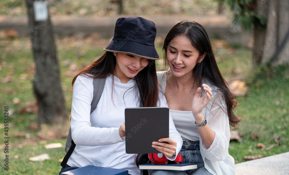 Group Of Asian Students Or Preparing For Lectures Outdoor, Studying With Tablet. Group Of Asian Students Or Preparing For Lectures Outdoor, Studying With Tablet.