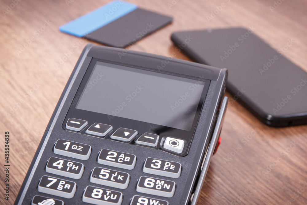 Payment terminal with credit card and mobile phone. Cashless paying for shopping. Finance concept Payment terminal with credit card and mobile phone. Cashless paying for shopping. Finance concept