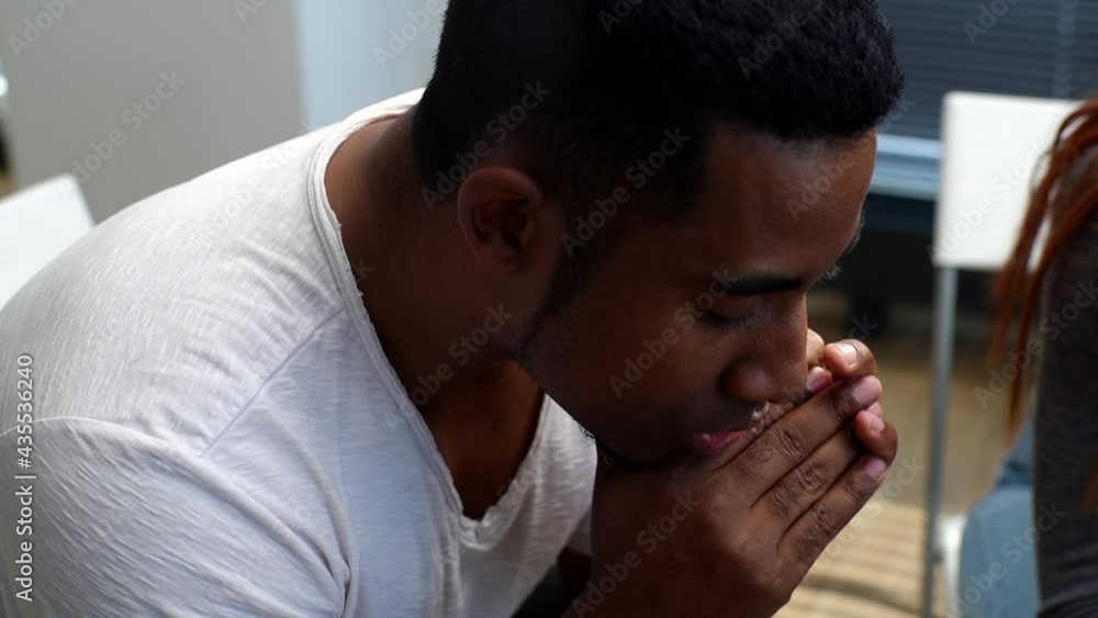 Close-up face of upset African American young man sharing problem sitting in circle on group interpersonal therapy session. Tracking shot of depressed black male telling sad story to other patients. Close-up face of upset African American young man sharing problem sitting in circle on group interpersonal therapy session. Tracking shot of depressed black male telling sad story to other patients.