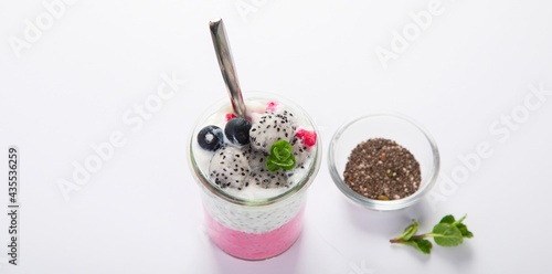Layered chia puding with pink filling on white background.