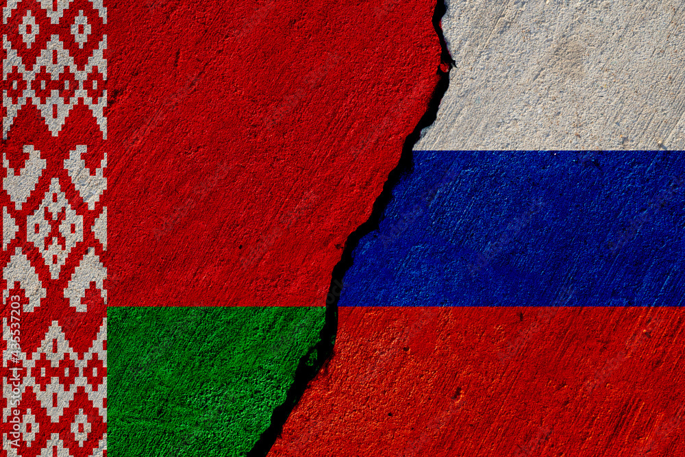 belarus and russia flags painted on cracked concrete wall