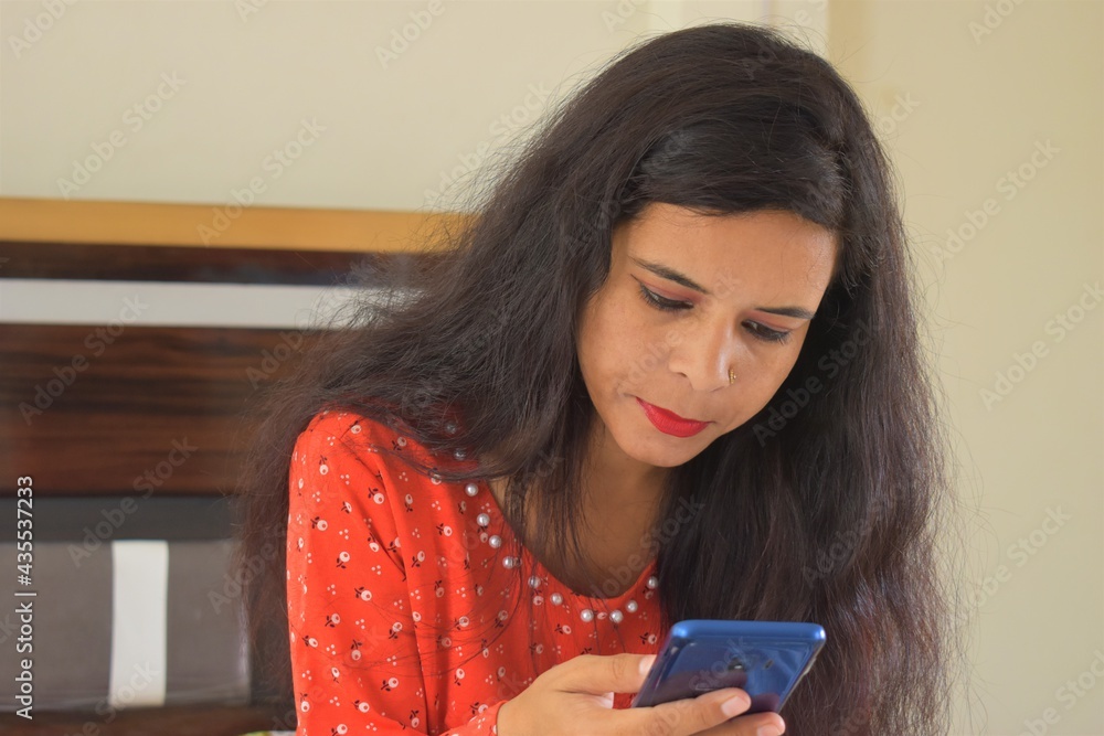 young Indian woman using mobile phone at home young Indian woman using mobile phone at home