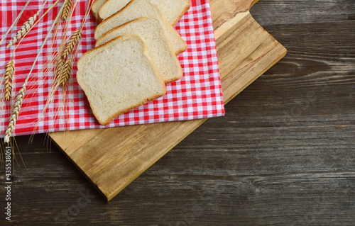 White bread toast with Wheat and red tablecloth on wooden background.