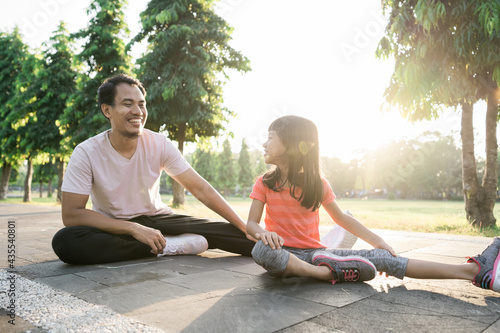 asian father and little daughter do exercises in outdoor. Healthy lifestyle of family with child