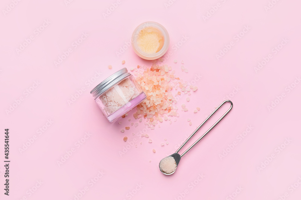 Jars of body scrub and sea salt on color background Jars of body scrub and sea salt on color background