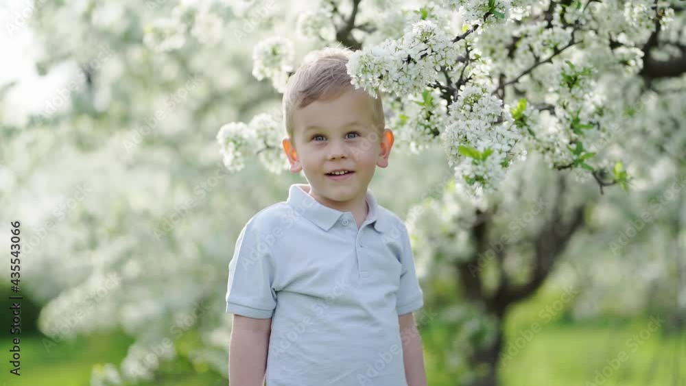 funny little boy in the flowering spring garden. happy childhood. funny little boy in the flowering spring garden. happy childhood.