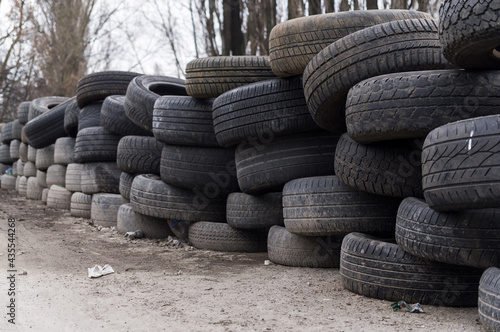 A wall made of old wheels. Wall made of old car tires. Fencing from wheels.