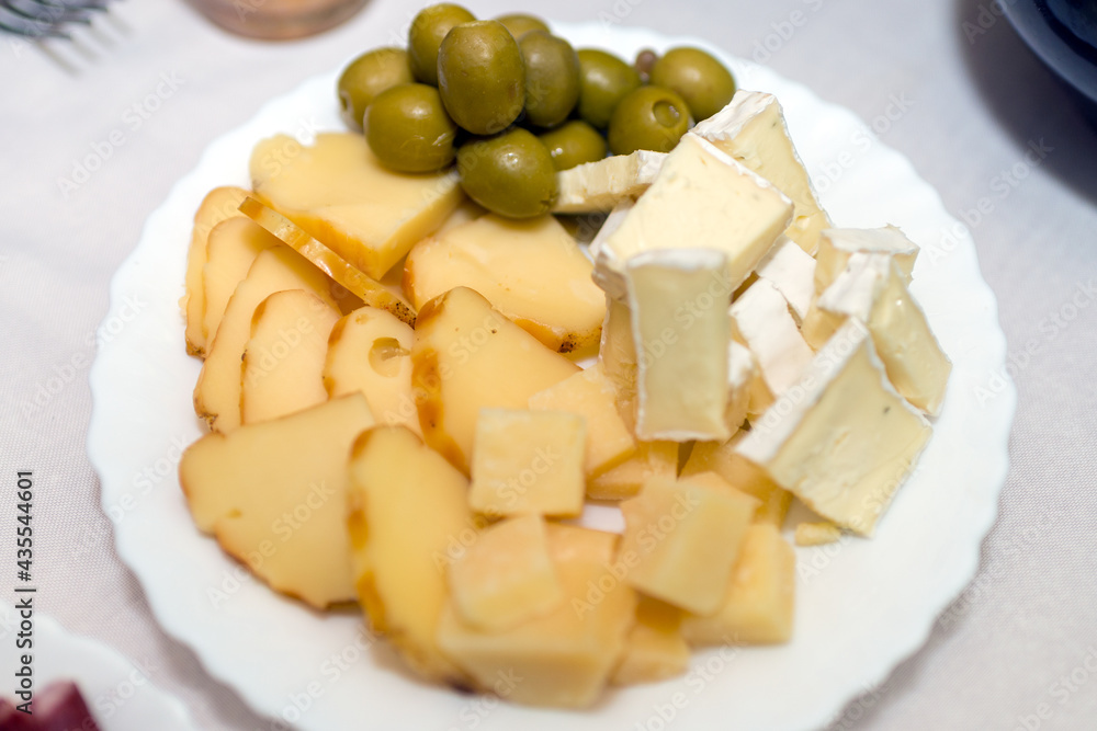 cheese plate with olives,mozzarella, gorgonzola on a white plate.Top view. cheese plate with olives,mozzarella, gorgonzola on a white plate.Top view.