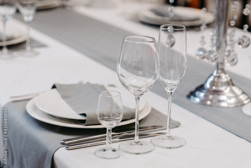 Table service in the restaurant. Transparent clean glasses and wine glasses. Christmas table decoration. Table service in the restaurant. Transparent clean glasses and wine glasses. Christmas table decoration.