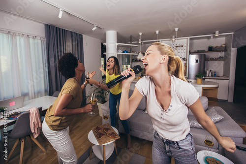 Photography Young womanl singing into microphone at home party having fun