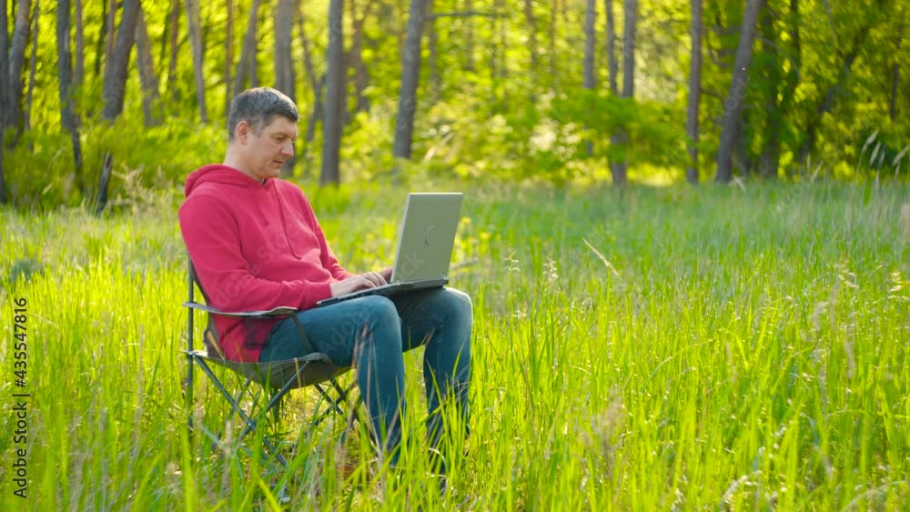 Man working on laptop in summer forest Man working on laptop in summer forest