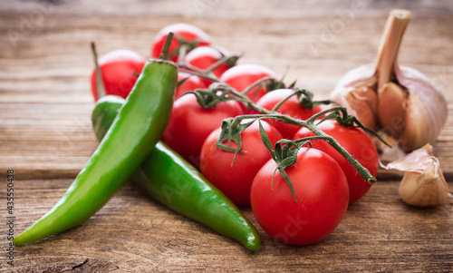 tomatoes with peppers and garlic on wooden background