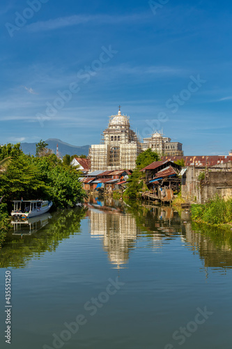 church with scaffolding and poor houses with sheet tin by the river, Kota Manado, North Sulawesi, Indonesia