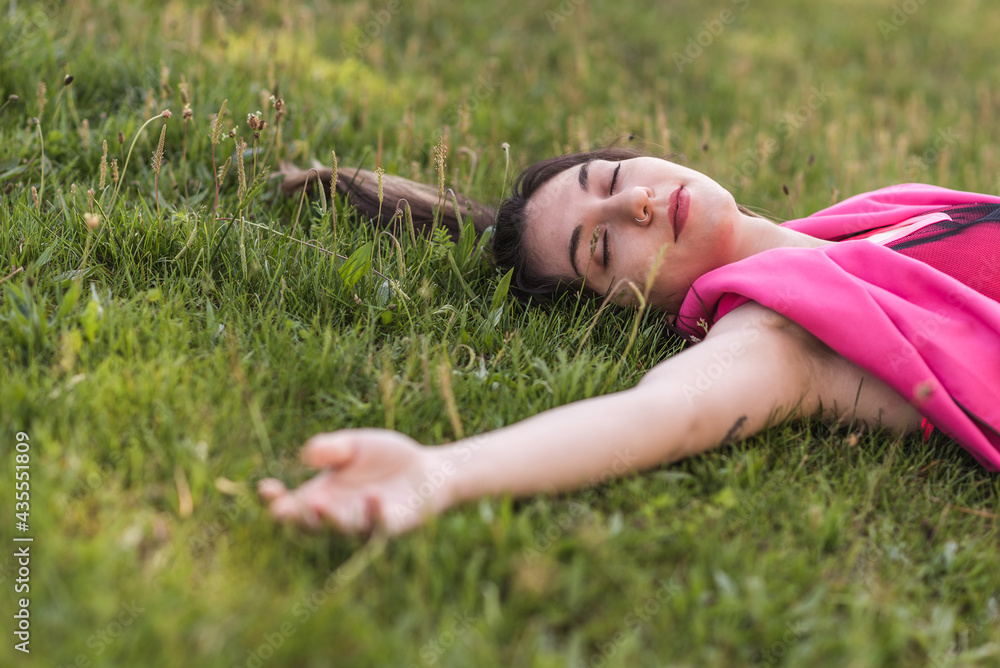 attractive caucasian woman laying on the grass with closed eyes attractive caucasian woman laying on the grass with closed eyes