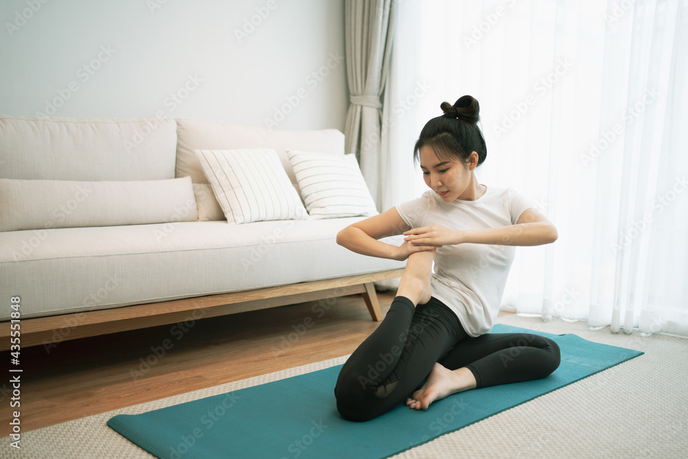 Portrait of gorgeous young asian woman practicing yoga at home stretching out while following a yoga routine. Portrait of gorgeous young asian woman practicing yoga at home stretching out while following a yoga routine.