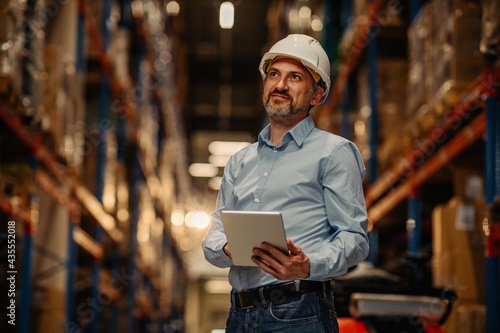 Man working in a warehouse via digital tablet photo