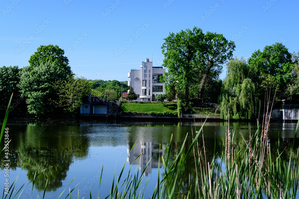 Landscape with old green trees near Mogosoaia lake and park, a weekend attraction close to  Bucharest, Romania, in a sunny spring day.