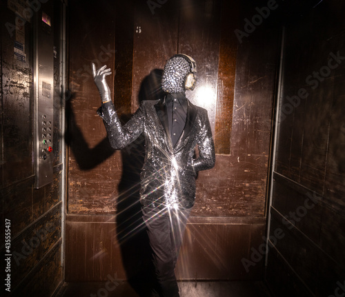 Sparkle masked man dancing in a lift