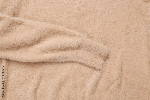 Soft beige fabric texture of sweater close up
