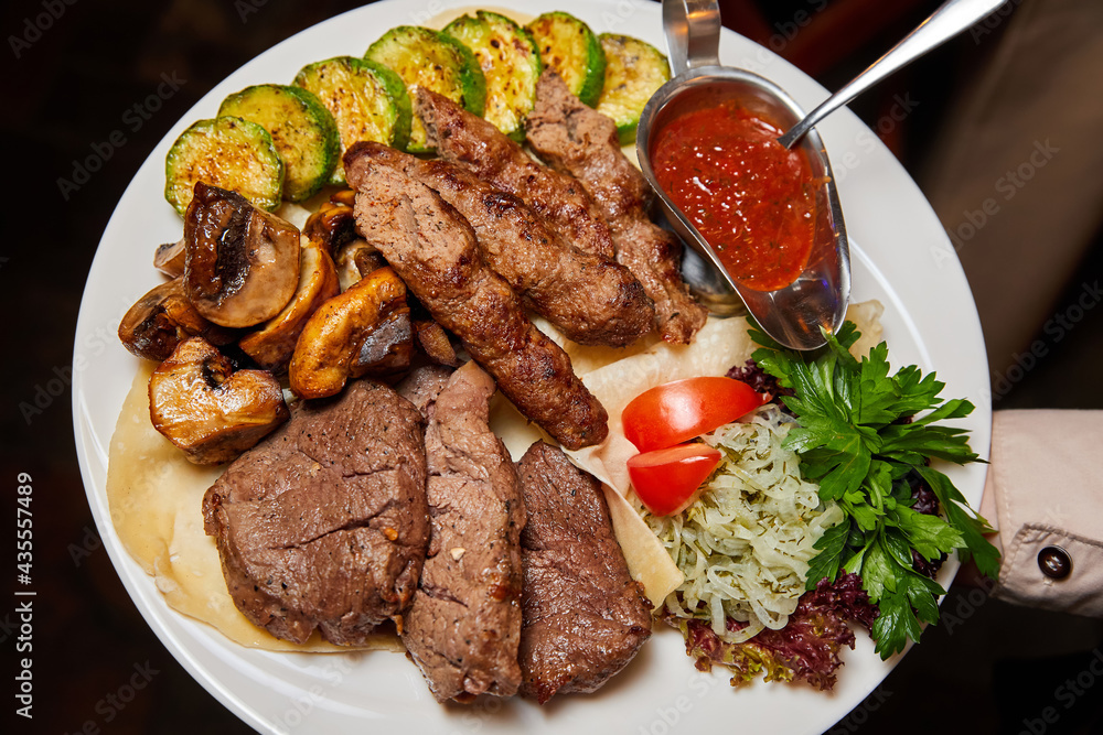 Beef lula kebab and shish kebab with grilled vegetables. Close-up, selective focus