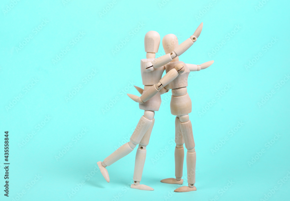 Two hugging wooden puppets on a blue background. Love, romantic concept Two hugging wooden puppets on a blue background. Love, romantic concept