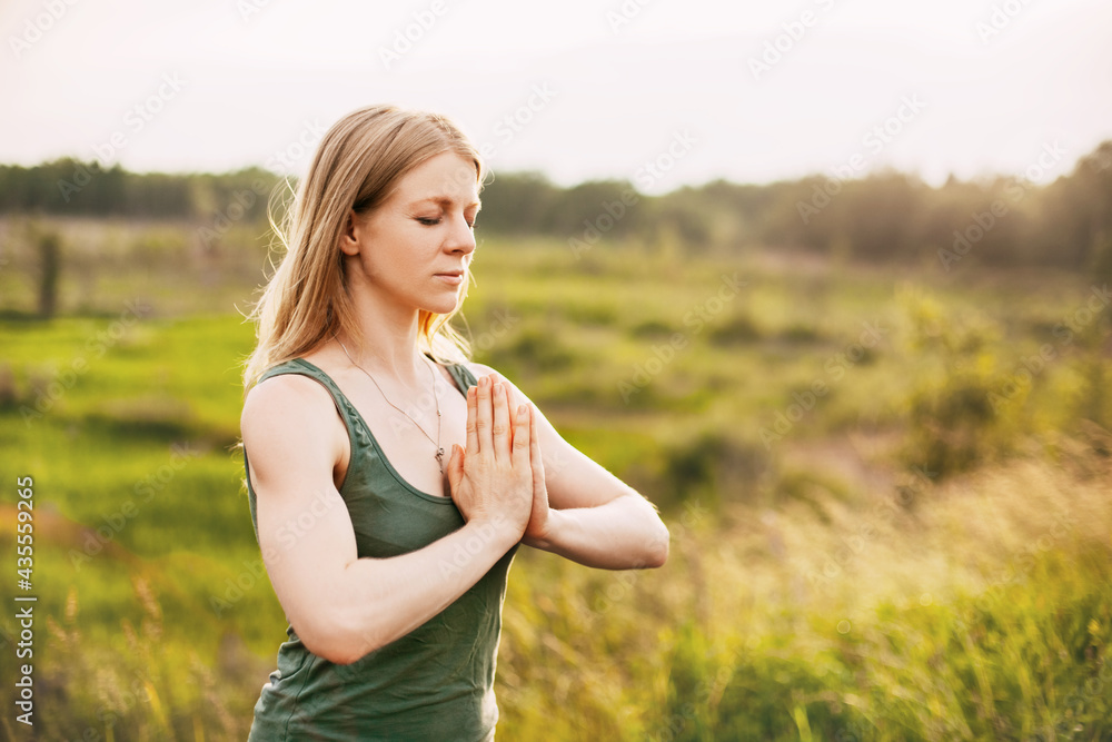 A young girl meditates after a yoga class in nature. The concept of mental health and healthy lifestyle A young girl meditates after a yoga class in nature. The concept of mental health and healthy lifestyle