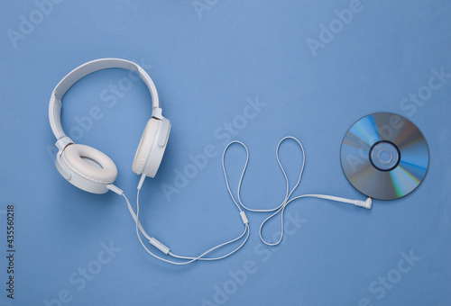 Musical layout. Headphones and cd on blue background. Top view. Flat lay